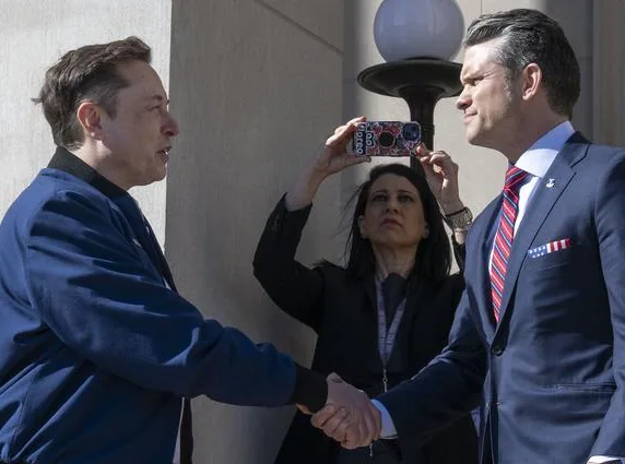Elon Musk shakes hands with Pete Hegseth